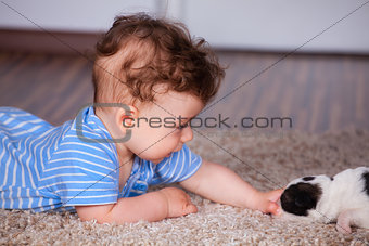 Baby boy playing with puppy