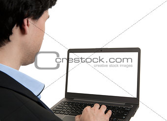Rear view of a business man working of a laptop