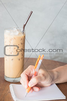 Hand writing on note paper in coffee shop 