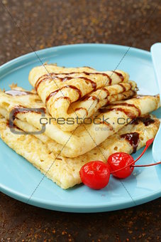thin pancakes with chocolate sauce on a plate