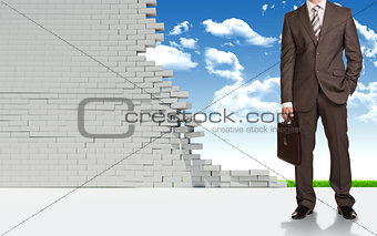 Businessman and ruined brick wall 
