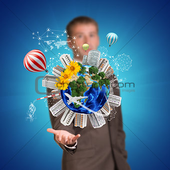 Businessman holding earth with buildings