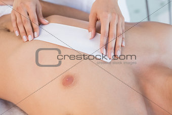 Beauty therapist waxing mans chest
