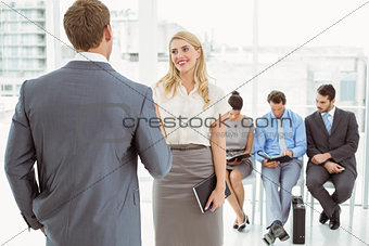 Businesspeople in front of people waiting for interview