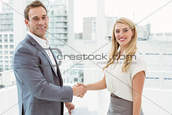 Happy executives shaking hands