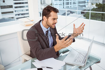 Frustrated businessman using laptop in office
