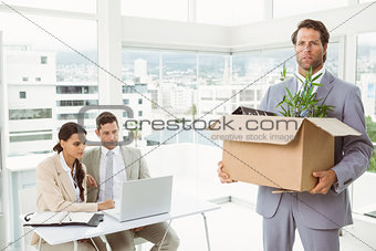 Businessman carrying his belongings in box