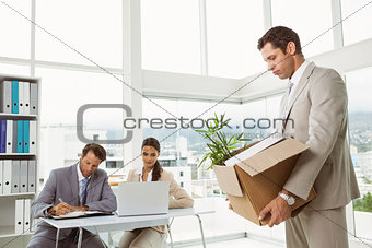 Businessman carrying his belongings in box