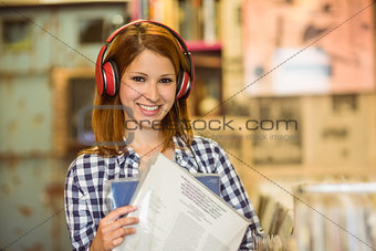 Smiling woman listening music and holding vinyls