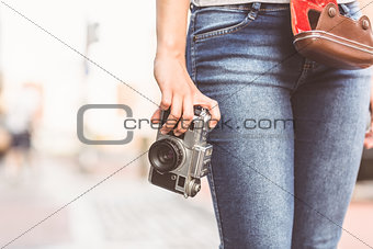 Close up of a girl wearing jean and holding a camera