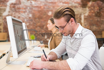 Male photo editor using digitizer in office