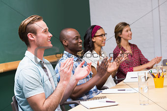 Colleagues clapping hands in meeting