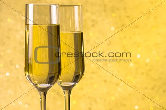 a pair of flutes of champagne golden abstract background