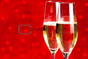 a pair of flutes of champagne red abstract background
