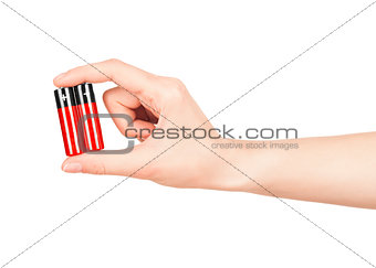 hand holds a red AA battery on an isolated white background