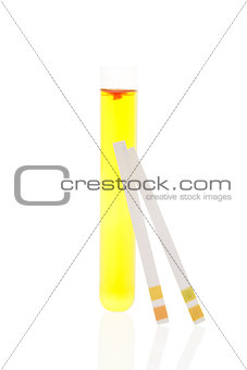 Urine in test tube and pH test strips.