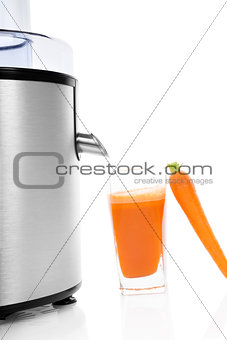 Juicer and fresh carrot juice isolated.