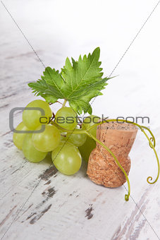 Green wine grapes with champagne cork.