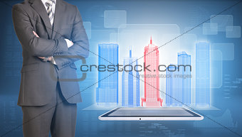 Businessman and wire-frame buildings on screen tablet pc