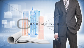 Businessman and wire-frame buildings on open empty book