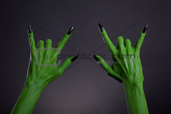 Green monster hands with black nails showing heavy metal gesture