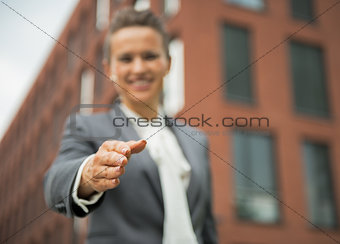 Closeup on happy business woman stretching hand for handshake in