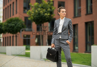 Business woman with briefcase in front of office building