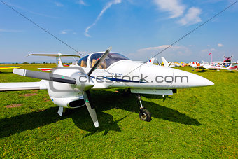 White airplane on a green grass field