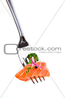 Delicious salmon piece on fork against white background.
