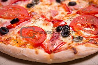 Delicious Italian pizza with ham, tomatoes and olives 