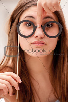 girl having fun with carton glasses