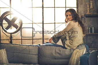 Portrait of young woman sitting in loft apartment