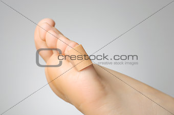 Closeup of a plaster on female toe