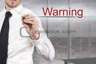 businessman writing warning in the air
