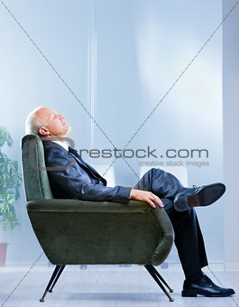 business man on an armchair with eyes closed