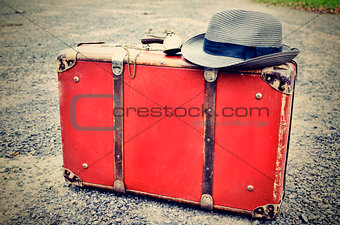 Old suitcase with watch and hat