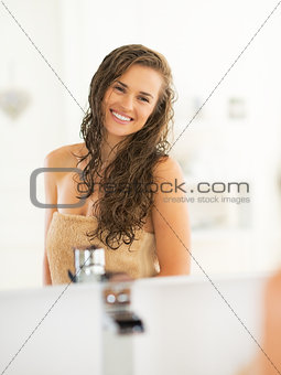 Portrait of happy young woman with wet hair in bathroom