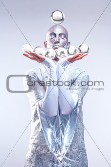 Magician with Glass Balls in Stage Makeup and Costume