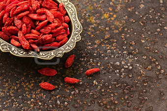 useful red goji berries on a old iron background