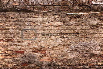 old brick wall with loose bricks and deteriorating mortar