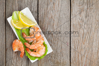 Cooked shrimps with lemon and salad leaves