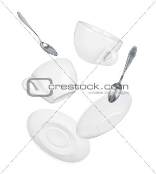 falling two cups and saucers with spoons isolated on white
