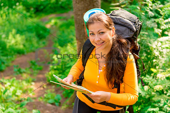 female with map and backpack smiling