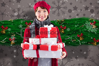 Composite image of smiling woman holding large presents