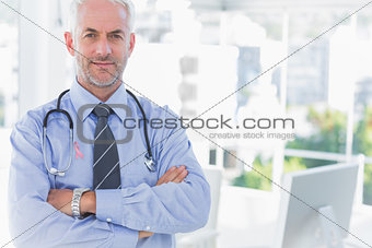 Composite image of doctor with arms crossed