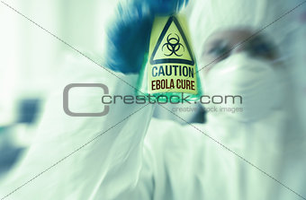 Scientist in protective suit holding beaker