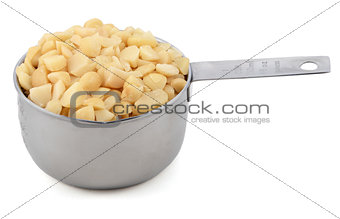 Chopped macadamia nuts in a cup measure