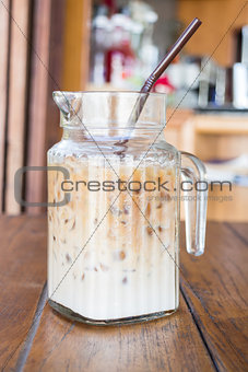 Iced coffee latte serving in glass pitcher