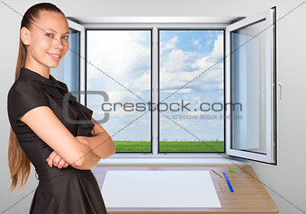 Beautiful businesswoman in dress smiling and looking at camera. Open window as backdrop