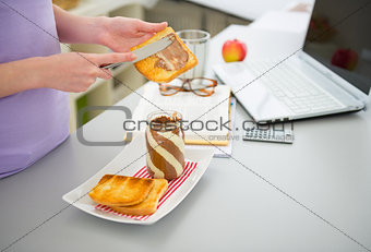 Closeup on young woman spread toast with chocolate cream